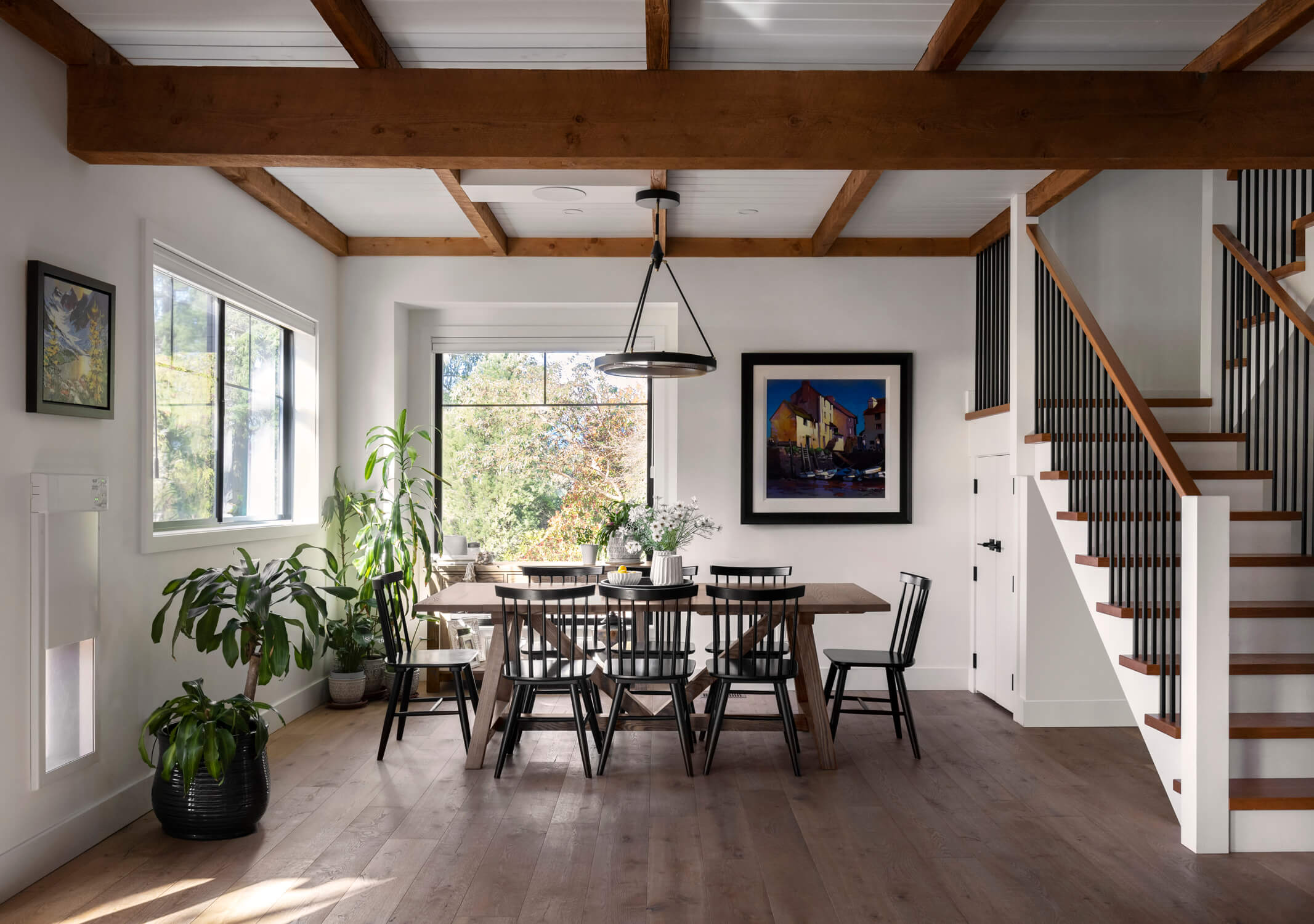 Reclaimed wooden beams line this modern farmhouse dining room area.