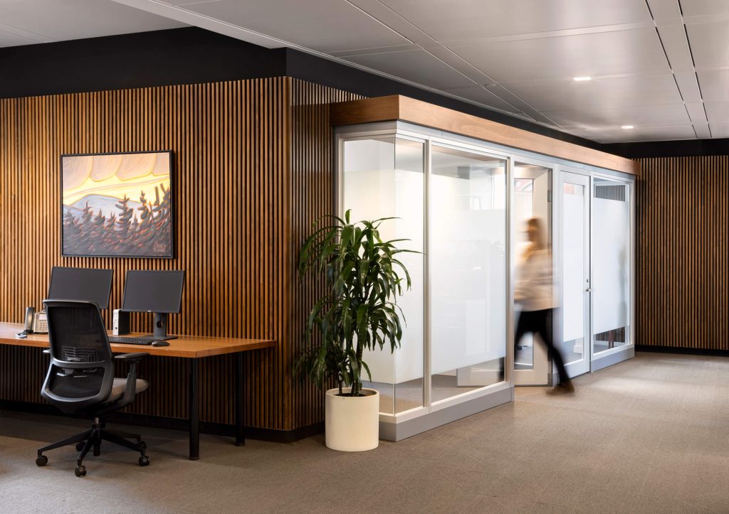 Office worker moves through modern wood grain accented corporate space, interior design photography by Tony Colangelo.