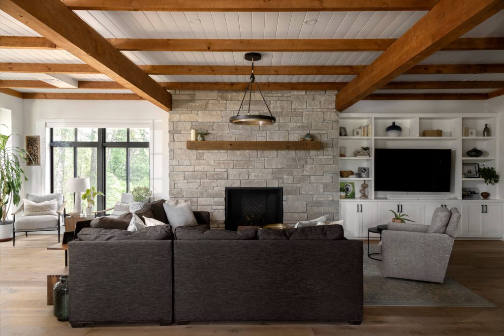 Modern wood timber country farmhouse fireplace and living area with bright floor to ceiling windows, interior design photography in Vancouver, Victoria and beyond.